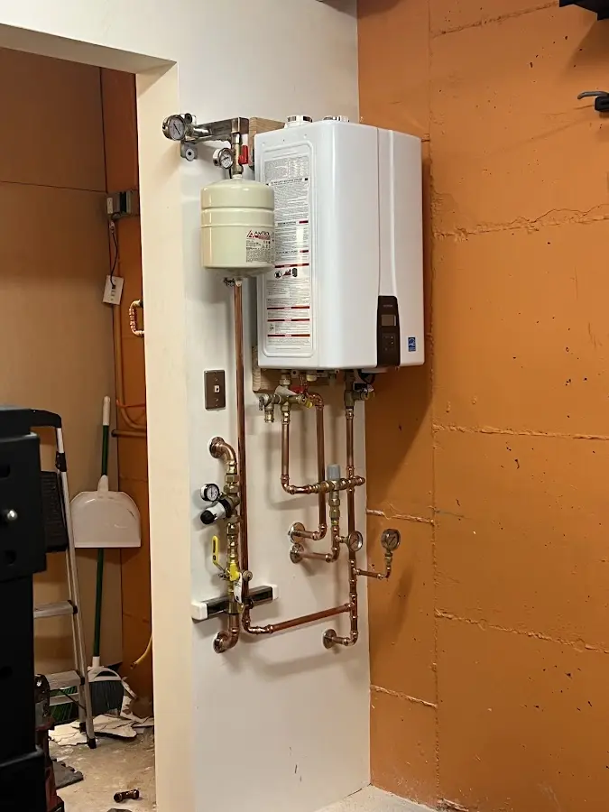 Plumbing technician inspecting water heater connections in Milford